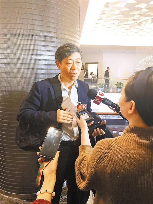 国政协委员、经济学家李稻葵在政协分组讨论会后接受记者的采访